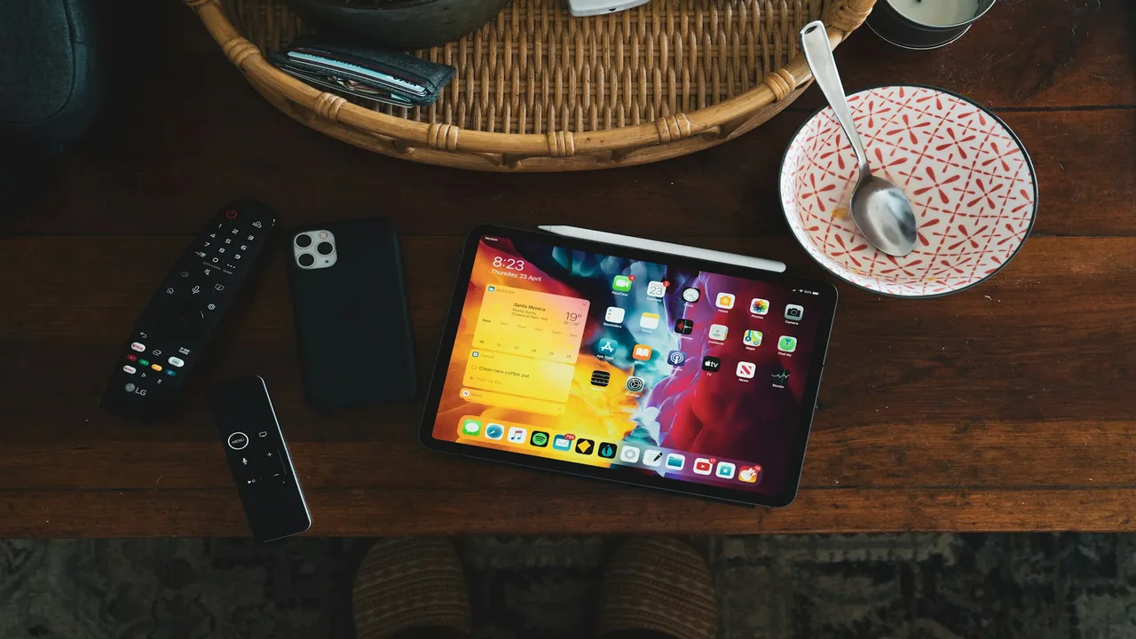 Television remote and tablet arranged neatly on a coffee table