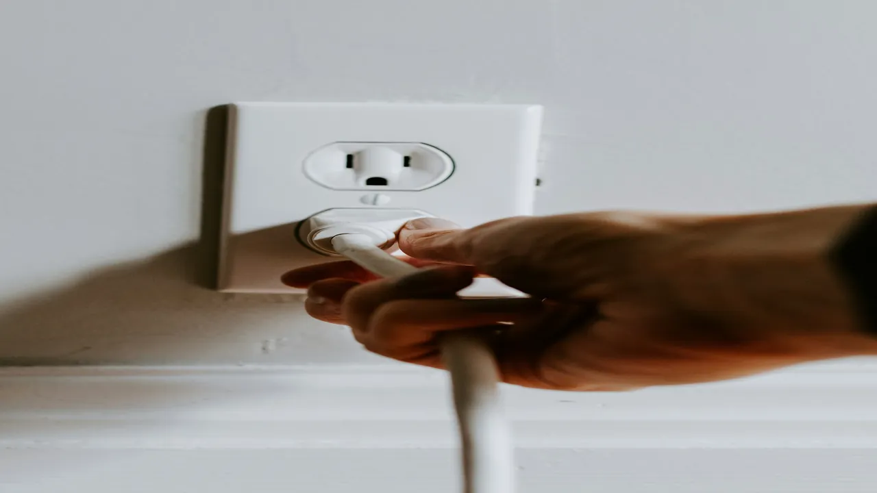 Hand unplugging the power cable of a streaming media player to restart it